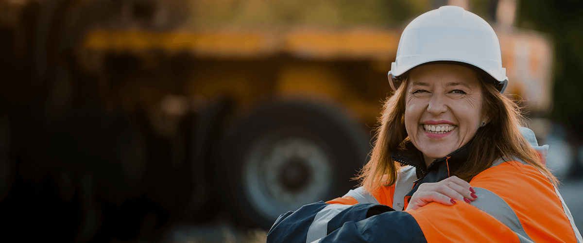 woman in orange hi-vis and white protective helmet smiling